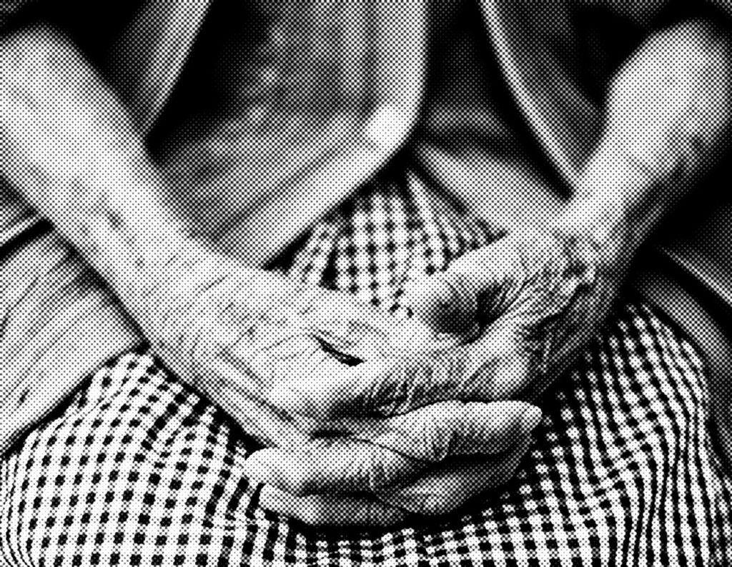 An elder woman waiting for help with her hands patiently folded on her lap