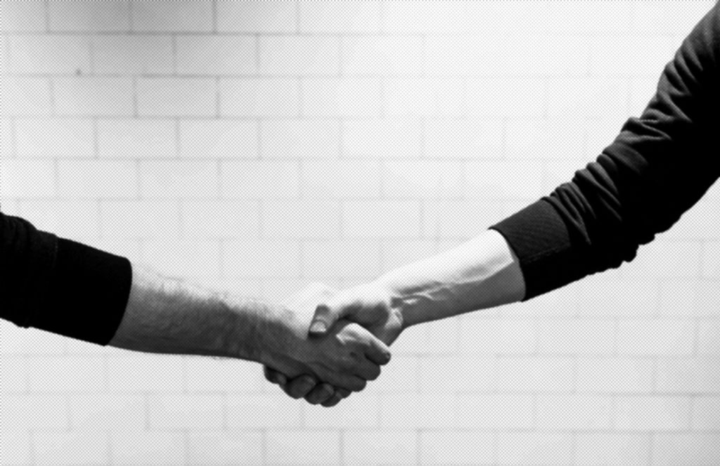 One person offering help and a handshake to another in their time of need.