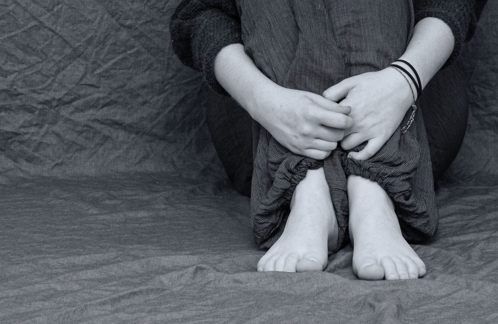 Human trafficking victim, sitting on the floor